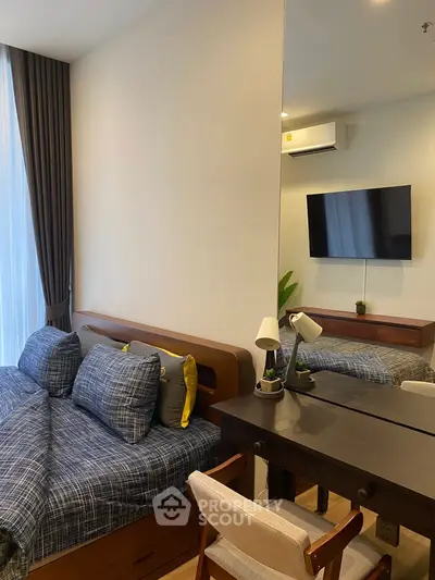 Modern bedroom with stylish decor, featuring a cozy bed, wall-mounted TV, and elegant desk setup.