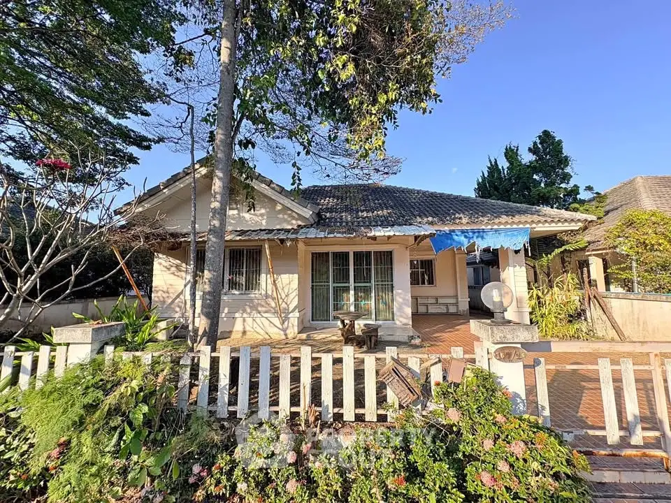 Charming single-story house with lush garden and white picket fence
