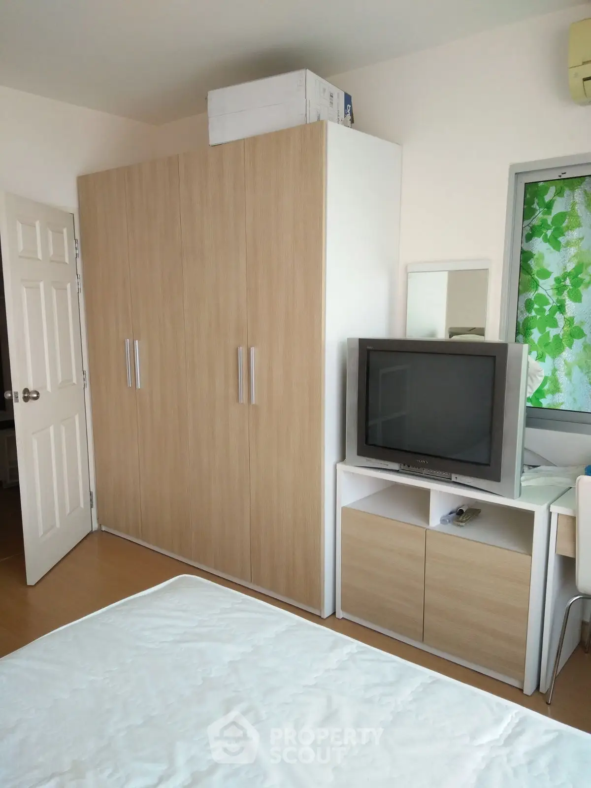 Cozy bedroom with modern wardrobe and TV setup, perfect for relaxation and entertainment.