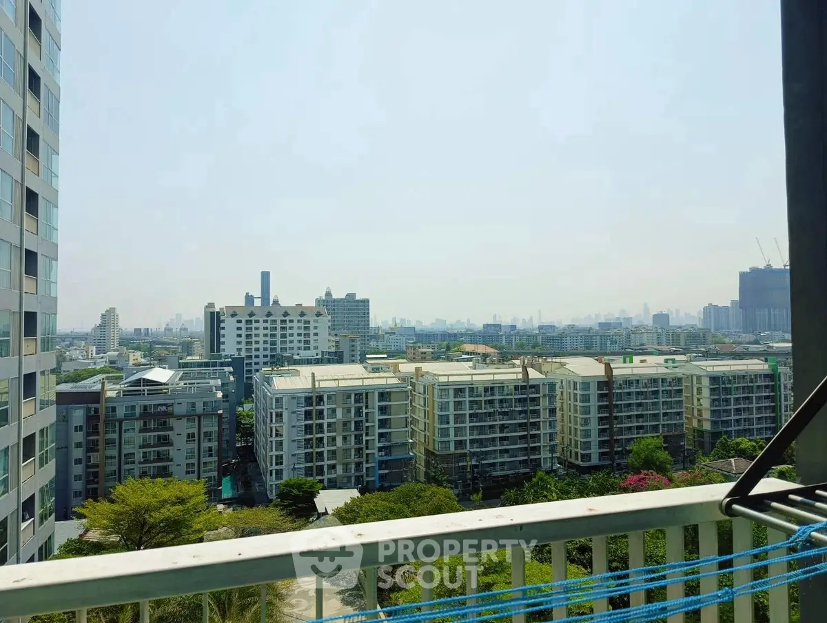 Stunning cityscape view from high-rise balcony, showcasing urban skyline and residential buildings.