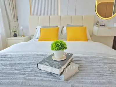 Luxurious bedroom with plush bedding and stylish decor, featuring vibrant yellow accents and modern furnishings.