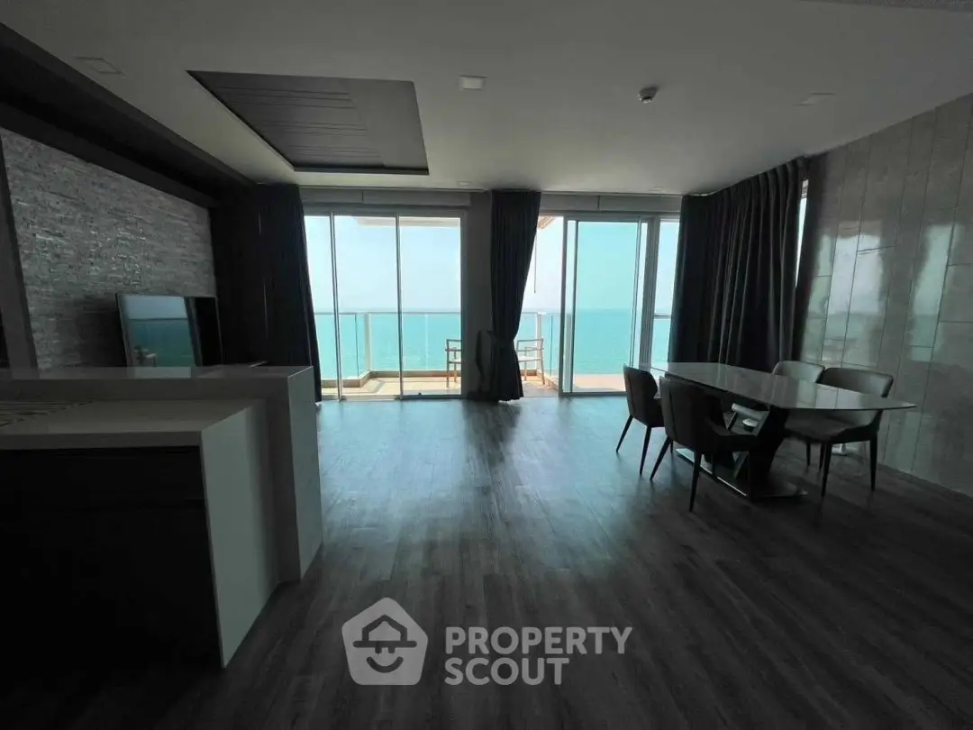 Stunning oceanfront living room with floor-to-ceiling windows and balcony access.