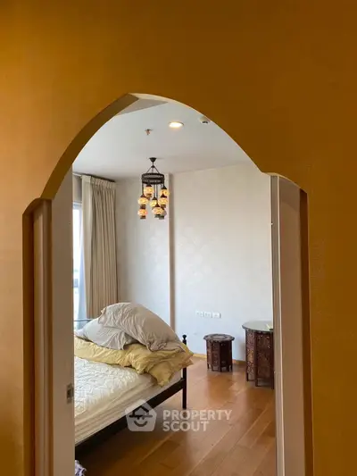 Elegant bedroom with unique archway entrance and stylish decor