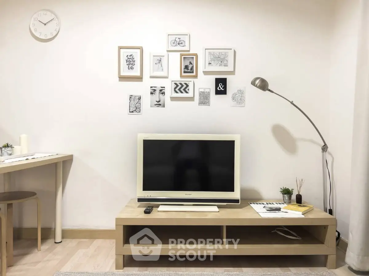 Modern living room with stylish decor and wall art, featuring a sleek TV setup and contemporary lighting.
