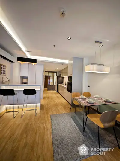 Modern open-plan living space with sleek kitchen, dining area, and stylish lighting, perfect for entertaining and comfortable living.