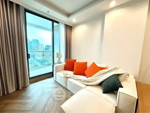 Modern living room with city view and cozy white sofa with colorful cushions.