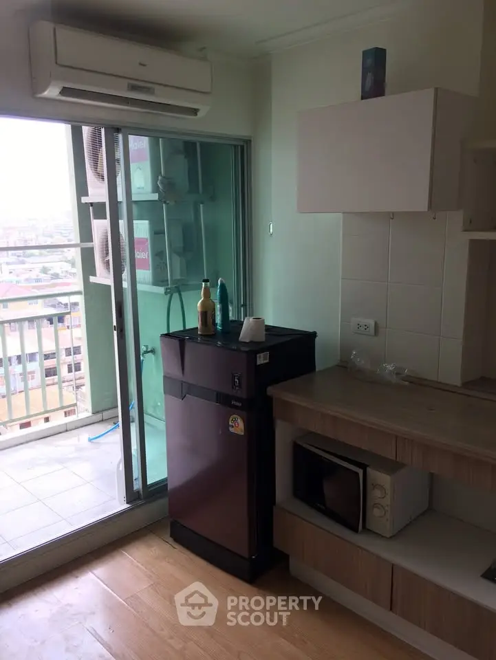 Compact kitchen with balcony view in modern apartment