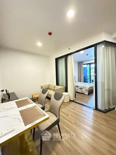 Modern open-plan living room with dining area and bedroom view