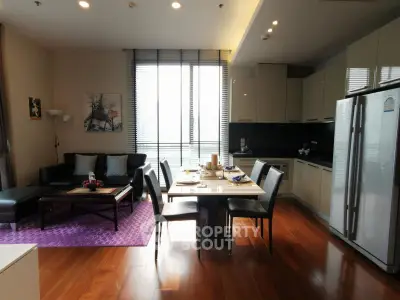 Modern open-layout living room and kitchen with stylish decor and natural light.