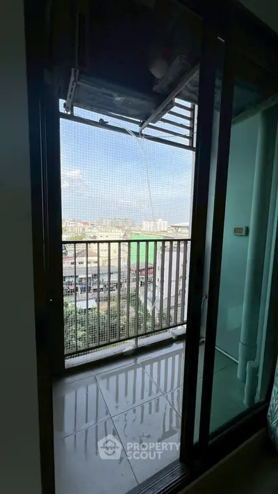 Modern apartment balcony with city view and sliding glass doors