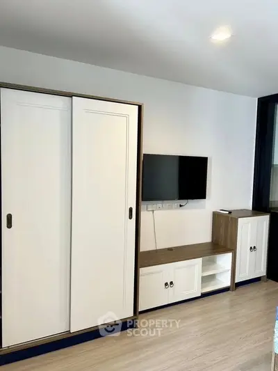 Modern living room with sleek white cabinets and mounted TV