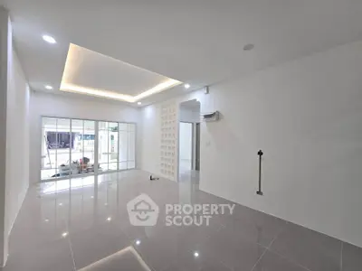 Spacious modern living room with glossy tiled floors and recessed lighting