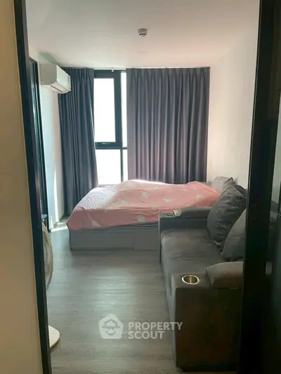 Cozy bedroom with modern decor and large window for natural light.