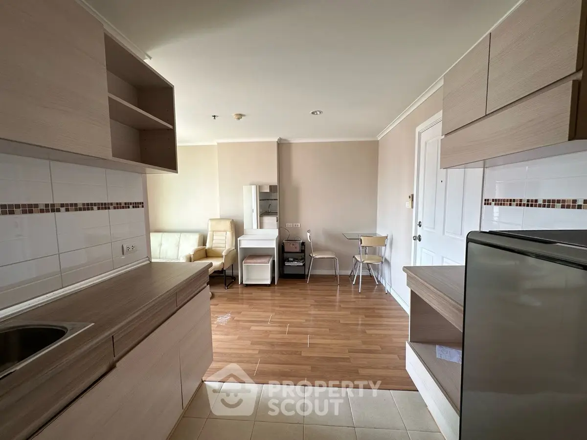 Modern open-plan kitchen and living area with stylish wooden flooring and sleek cabinetry.