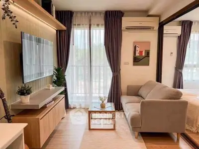 Modern living room with stylish decor and natural light, featuring a cozy sofa and wall-mounted TV.