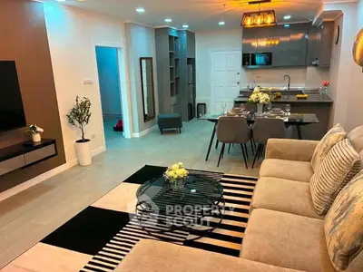 Modern open-layout living room with stylish decor and kitchen area, perfect for entertaining.