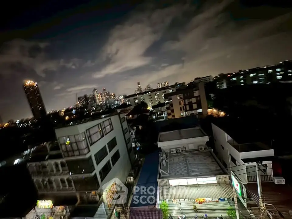 Stunning cityscape view from a high-rise building at night, showcasing urban skyline and vibrant lights.