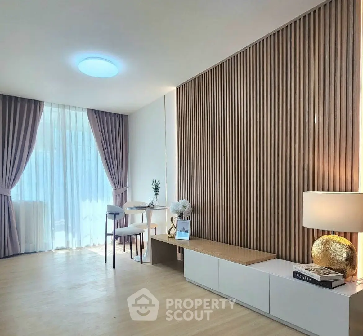 Modern living room with elegant decor and natural light, featuring stylish furniture and wooden accents.