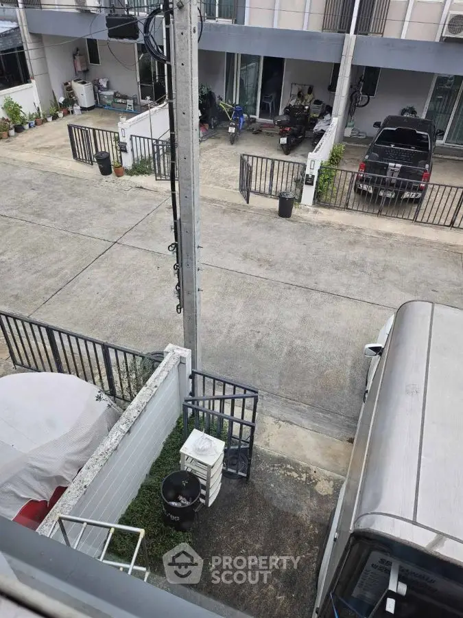 Street view of residential area with parked vehicles and gated homes