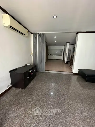 Spacious living room with modern air conditioning and sleek flooring, ideal for comfortable living.