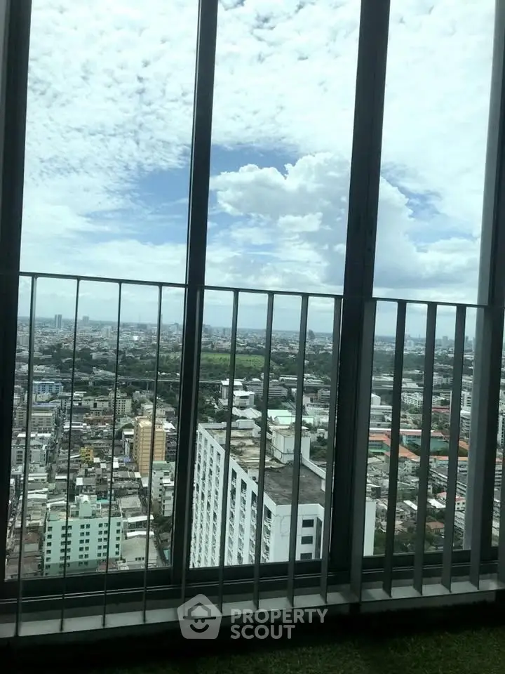 Stunning cityscape view from a high-rise balcony with expansive skyline and lush greenery.
