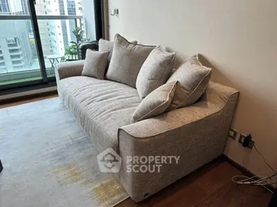 Modern living room with stylish sofa and city view balcony, perfect for urban living.
