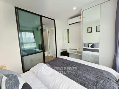 Modern bedroom with mirrored closet and sleek design in a contemporary apartment.