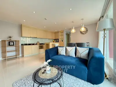 Modern open-layout living room with stylish kitchen and cozy blue sofa