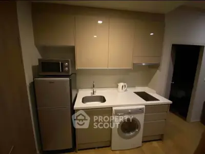 Modern compact kitchen with integrated appliances and sleek cabinetry