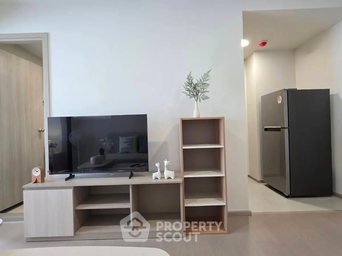 Modern living room with sleek TV stand and refrigerator in open layout