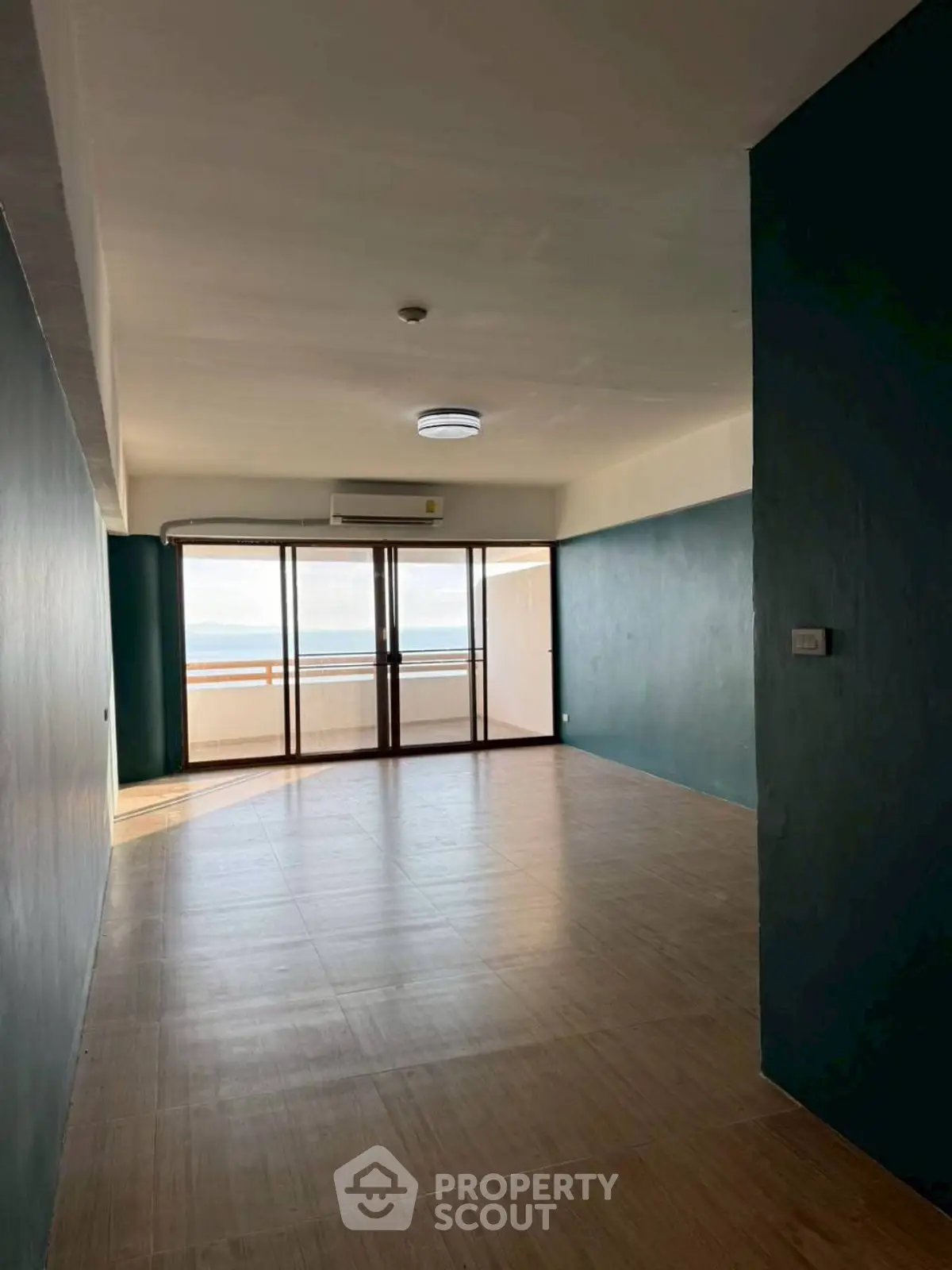 Spacious living room with large windows offering stunning sea views and ample natural light.
