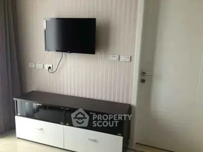 Modern living room with wall-mounted TV and sleek storage unit.