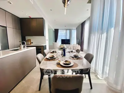 Luxurious open-layout kitchen and dining area with modern furnishings and ample natural light.