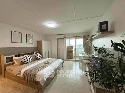Spacious bedroom with modern decor and balcony access, featuring stylish furniture and natural light.