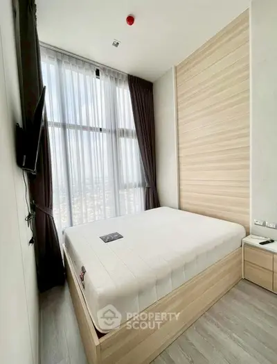 Modern bedroom with large window offering stunning city views, featuring sleek wooden accents and minimalist design.