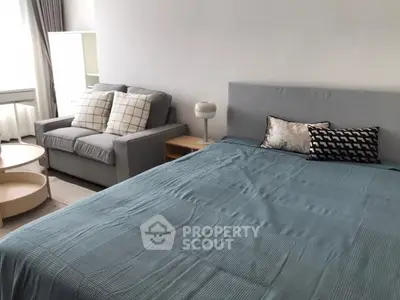 Spacious bedroom with modern decor and cozy seating area, perfect for relaxation.