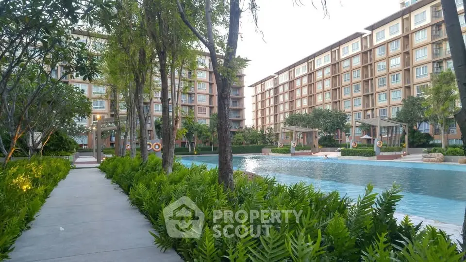 Luxurious apartment complex with serene pool and lush greenery