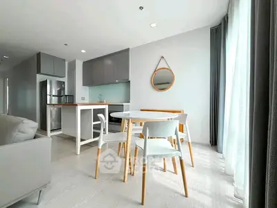 Modern open-plan living and dining area with sleek kitchen design and natural light.