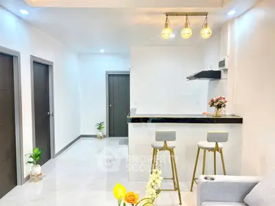 Modern open-layout kitchen with sleek bar stools and elegant lighting