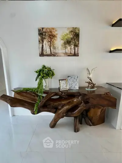 Elegant interior with unique wooden console table and artistic decor in a modern living space.
