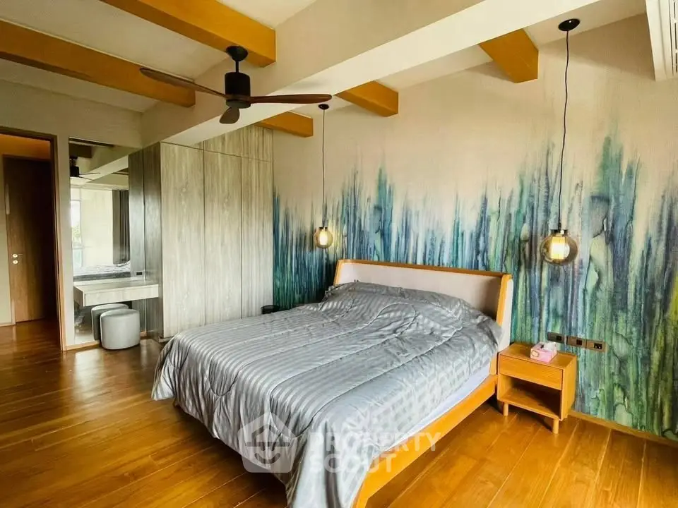 Modern bedroom with artistic wall design and wooden flooring
