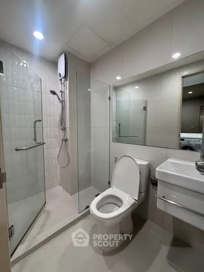 Modern bathroom with glass shower and sleek fixtures in a contemporary apartment.