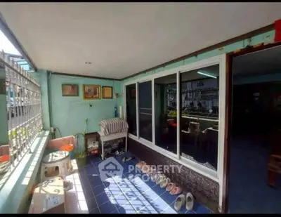 Charming enclosed balcony with blue tiles and sliding glass doors, perfect for relaxation.