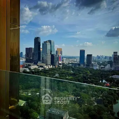 Stunning cityscape view from a high-rise balcony overlooking lush greenery and skyline.