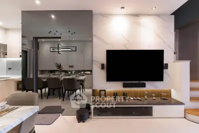Modern living room with sleek TV setup and elegant dining area, showcasing contemporary interior design.