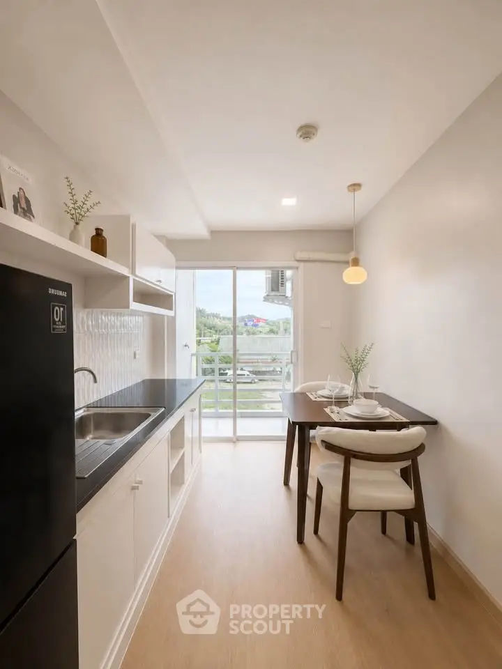 Modern kitchen with dining area and balcony view in a stylish apartment