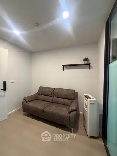 Cozy living room with modern sofa and portable air conditioner, perfect for relaxation.