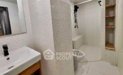 Modern bathroom with sleek fixtures and tiled walls, featuring a shower and toilet.
