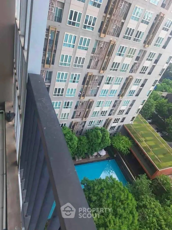 Stunning high-rise building view with pool and lush greenery from balcony.