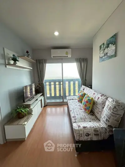 Cozy living room with modern decor and balcony view, featuring a stylish sofa and entertainment setup.